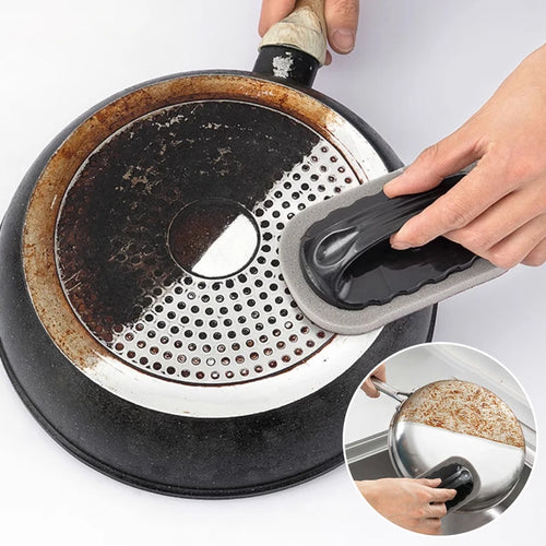 Brosse de nettoyage ergonomique utilisée pour nettoyer le dessous d’une casserole très sale, montrant l’efficacité pour enlever les résidus brûlés et la graisse sur les ustensiles de cuisine.
